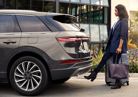 A woman with her hands full uses her foot to activate the available hands-free liftgate. | Lincoln of Coconut Creek in Coconut Creek FL