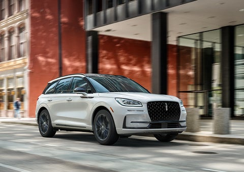 The 2024 Lincoln Corsair® SUV with the Jet Appearance Package and a Pristine White exterior is parked on a city street. | Lincoln of Coconut Creek in Coconut Creek FL