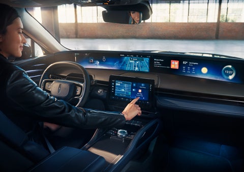 The driver of a 2024 Lincoln Nautilus® SUV interacts with the center touchscreen. | Lincoln of Coconut Creek in Coconut Creek FL